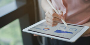 close up on businesswoman manager hand using stylus pen for writing or comment on screen dashboard tablet in meeting situation about company's performance , technology and business strategy concept