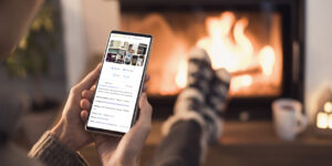 Female holding mobile phone in winter. A Google Business Profile (GBP) page for a coffee shop is on the screen.